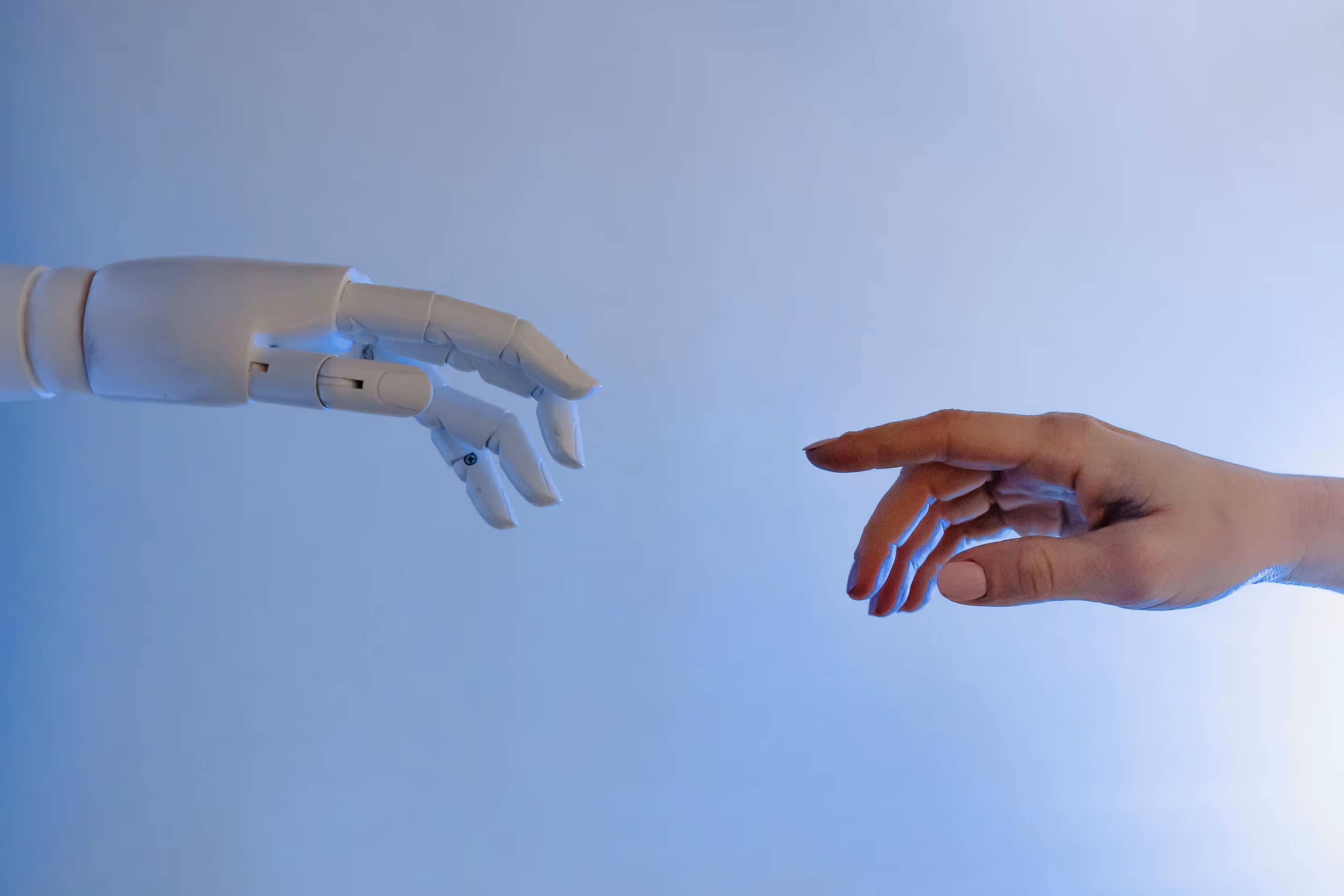 A robotic hand and a human hand reaching towards each other