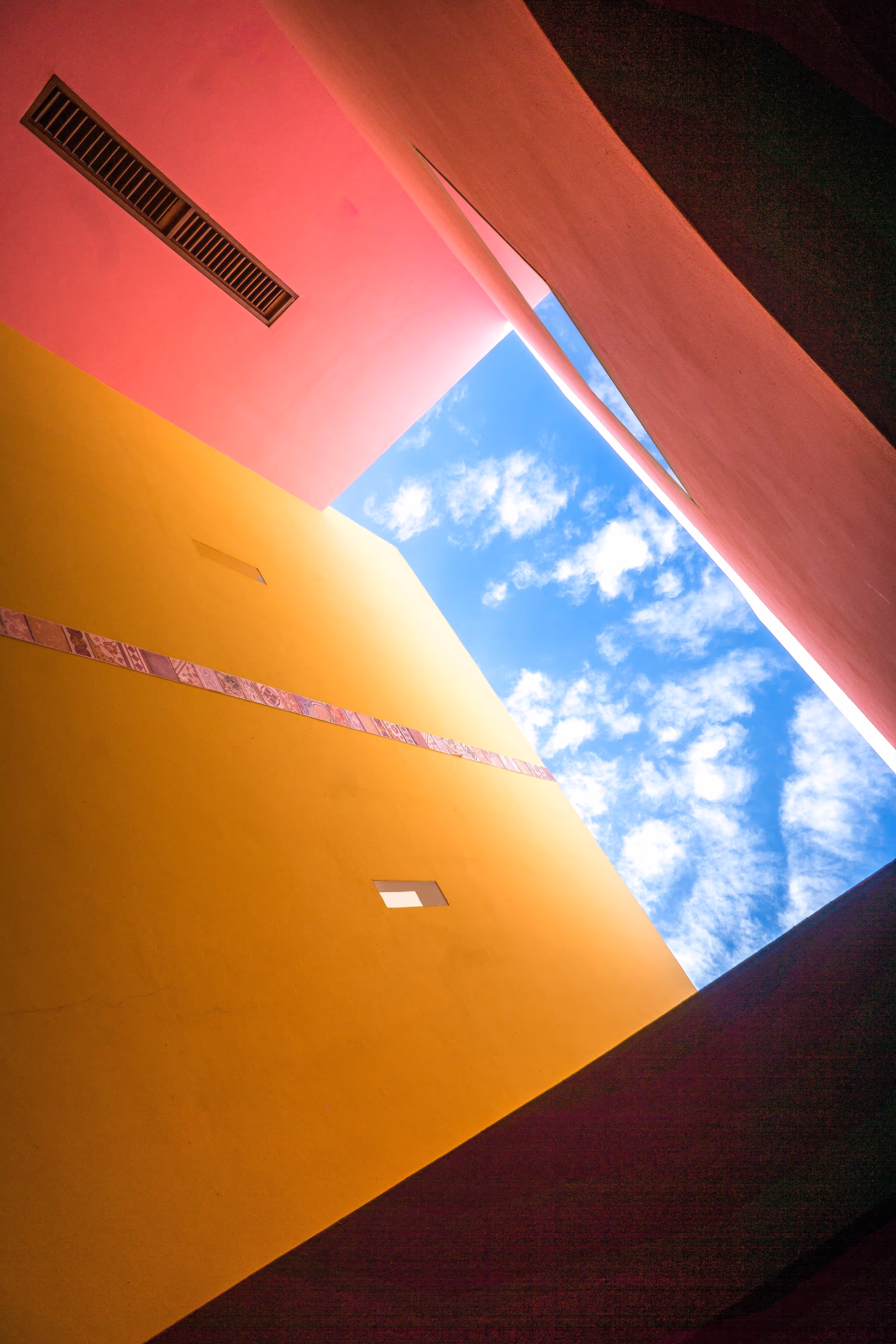 An orange building façade against an open sky